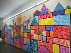 an art project is displayed on the wall in this school's hallway, which features brightly colored blocks and shapes