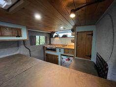 the interior of an rv with wood paneling and cabinets on the walls, including a bed