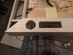 an unfinished table is being built with tools and materials around it, including a hole in the middle