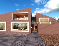 an artist's rendering of a brick house with large windows and wooden decking