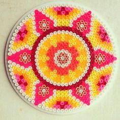 a colorful beaded artwork on a white plate