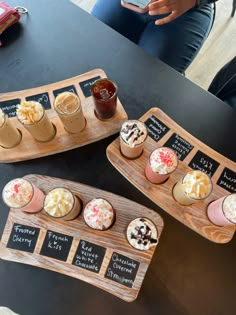 two wooden trays filled with different types of pastries on top of a table