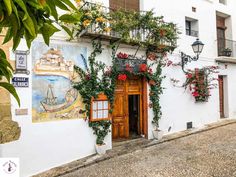 a white building with flowers growing on it's side