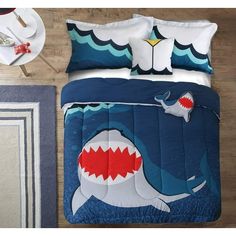 a bed room with a neatly made bed and a shark comforter on the floor