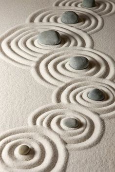 several stones are arranged in the shape of spirals on top of snow covered ground