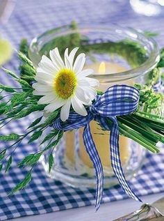 a vase filled with flowers sitting on top of a blue and white checkered table cloth