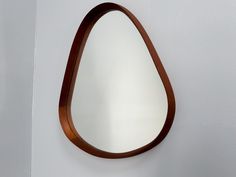 a wooden mirror hanging on the wall