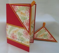 an open card with flowers on it and two folded cards next to eachother