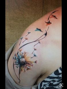 a woman's stomach with a dandelion tattoo design on it, and birds flying around