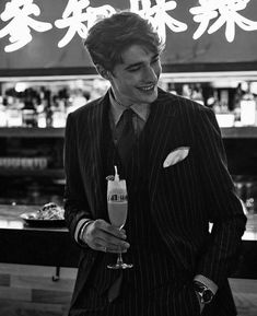 a man in a suit and tie holding a drink