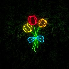 a neon sign with three tulips and a bow on it's side