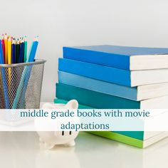 a stack of books sitting next to a cup with pencils in it