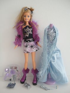 a barbie doll with clothes and shoes next to a dress up outfit on a mannequin