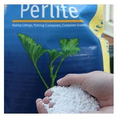 a person holding something in their hand near a bag of fertite on the ground