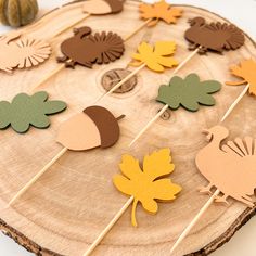 a wooden slice with leaves and acorns on it