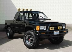 a black pick up truck parked in front of a building