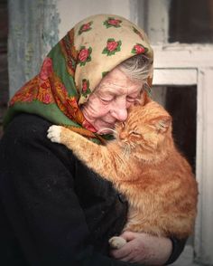 an old woman holding a cat in her arms