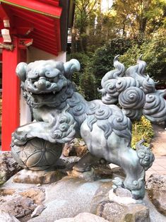 a statue of a foo foo dog in front of a red building