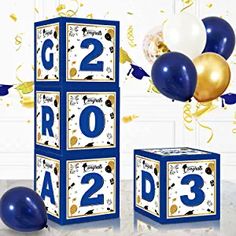 two blocks with numbers and balloons in front of them, one is blue and the other is gold