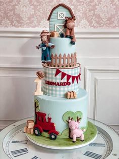 a three tiered cake decorated with farm animals