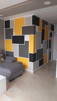 a living room filled with furniture and walls painted in shades of grey, yellow and white