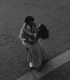 a man and woman hugging on the street