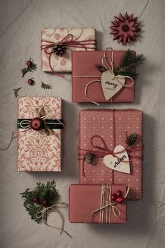 presents wrapped in pink and red paper with bows, pine cones and hearts on them