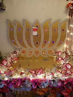 an elaborately decorated table with lights and decorations on it's sides, in front of a white wall