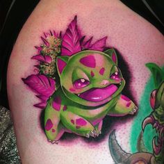 a close up of a person's thigh with tattoos on it and a cartoon character in the background