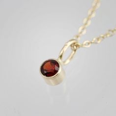 Very classy, simple, and dainty. This handcrafted gold pendant has a natural Garnet stone and comes on your choice of a 16 or an 18 inch gold chain with the artist's tag attached to the clasp. It can also be paired with other pendants! Mix and match to create your own personalized necklace or mother necklace! Gold is 14ky. Stone measures 3mm in diameter. Birthstone for January. All Laine Benthall jewelry comes with a lifetime warranty. This pendant can also be purchased without the chain, just g 14k Gold Necklace With Bail For Gift, Mother Necklace, Mothers Necklace, Garnet Stone, Drop Necklace, Personalized Necklace, Necklace Gold, Gold Pendant, Pendant Necklaces