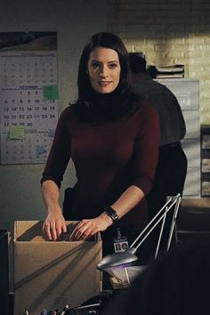 a woman standing next to a box in an office