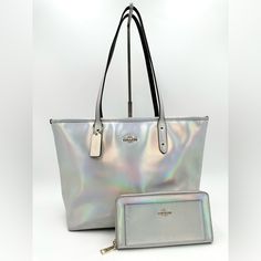 Bright And Fun, This Limited Edition Holographic Coach Tote And Matching Wallet Is The Perfect New Addition To Your Purse Collection! Color: Silver Holographic Iridescent Condition: Good. Clean. Slight Signs Of Wear On Corners Of The Bag, Side Of Bag, Bottom Of Bag And Back Of Bag. Wallet Is In Great Condition As Well. *Approx* Measurements: Tote: 12” X 5.5” X 11” Strap Drop 10” Wallet: 8” X 4” Coach Silver Wallets For Everyday Use, Coach Silver Wallet For Everyday Use, Holographic Iridescent, Purse Collection, Silver Holographic, Coach Tote, Zip Tote, Leather Silver, Designer Bags