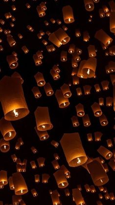 many lit up lanterns floating in the air