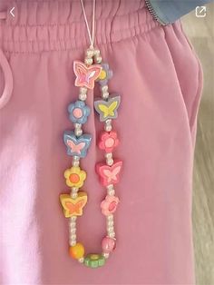 a close up of a child's pink pants with beads and butterflies on it