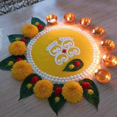 a decorated cake with candles and flowers on the table in front of it for diwaling