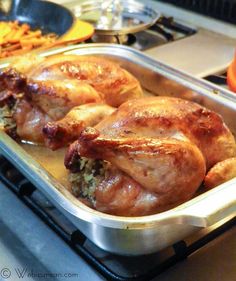 two roasted chickens in a pan on the stove