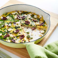 a casserole dish with spinach, feta cheese and olives