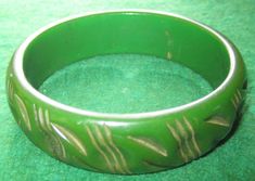 "A Vintage 1940's Carved Green Bakelite Bangle Bracelet. Visit this shop for a wide variety of Vintage Quality Jewelry, Art, Photos and Collectibles. ~Age (approximate): 1940's ~Material(s): Bakelite ~Approx. Size: 2 1/2\" across ~Approx. Weight: N/A ~Signature / Brand: Unsigned. ~Condition: Very Good +. ~International Shipping: Is Available, please contact us for a quote. ~Inventory #: 3871" Bakelite Bracelets, Bakelite Jewelry, Bakelite Bangles, Art Photos, Quality Jewelry, Bangle Bracelet, Dog Bowls, Jewelry Art, Serving Bowls