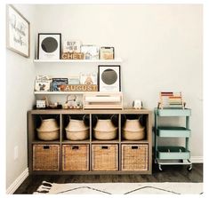 a shelf with baskets and pictures on it in a living room next to a rug