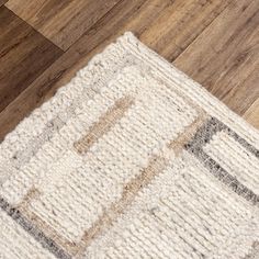 an area rug on the floor with wooden floors and wood planks in the background