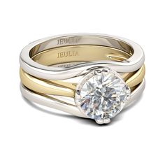 a white and yellow gold engagement ring with a round diamond in the center, on a plain band