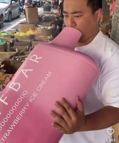 a man holding a pink ice cream container