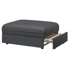 a grey ottoman with two drawers underneath it and an open drawer under the foot rest