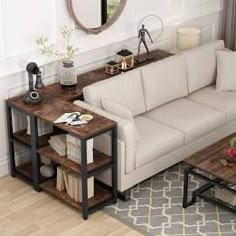 a living room with a couch, coffee table and mirror on the wall next to it