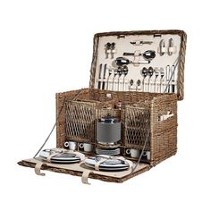 a wicker picnic basket with utensils and silverware in it, sitting on a white background