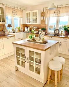 a kitchen filled with lots of white cabinets and counter top next to a wooden floor