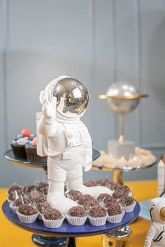 an astronaut cake and cupcakes on a table