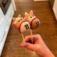 someone is holding two cake pops with cows on them