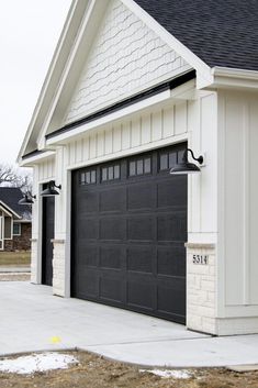 a white house with a black garage door