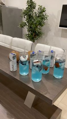 there are many glasses with blue liquid on the table